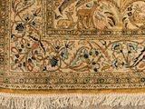 an antique persian rug with birds and flowers on a beige ground