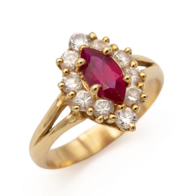un gros plan d'une bague en or sertie d'un rubis et d'une topaze blanche