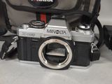 a silver camera and a black bag on a table