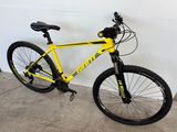 un vélo jaune garé dans un garage, près d'un mur blanc