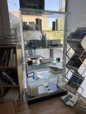 a glass display case with magazines on it in a room