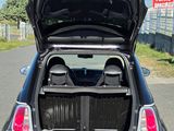 a small car with its trunk open on the street