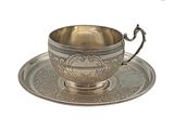 tasse à thé et soucoupe plaquées argent, posées sur une soucoupe