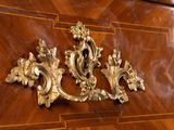 a close up of a wooden cabinet with a gold decoration
