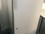 a white refrigerator sitting in a kitchen next to a blue trash can