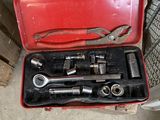 une boîte à outils rouge avec des outils sur le sol