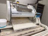 une machine qui prépare de la pâte sur un tapis roulant