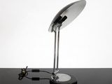une photo d'une lampe de bureau posée sur une table noire
