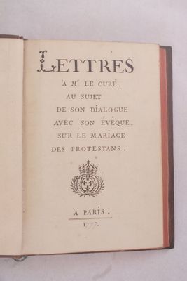 un livre ouvert posé sur une table blanche bordée de rouge