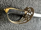 a close up of a sword laying on the ground on a carpet