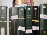 several books are stacked on top of each other on a shelf