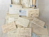 several old letters and envelopes are in a box on a table