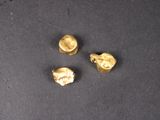 trois pièces d'or sont représentées sur un fond noir