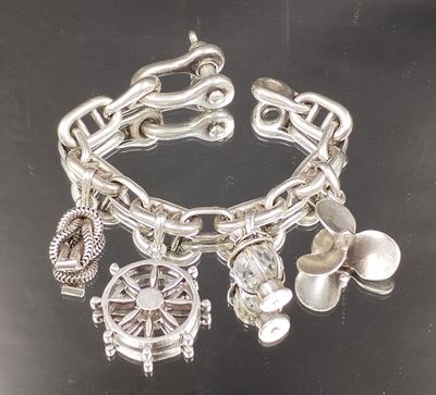 un bracelet en argent orné de breloques, posé sur un fond noir