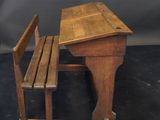 a small wooden desk and a chair on a black surface