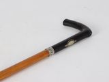 a wooden stick with a black handle on a white surface