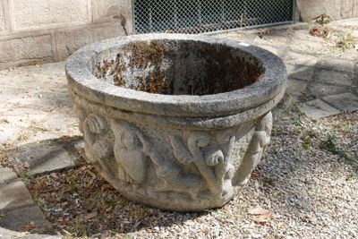 une jardinière en pierre posée au milieu d'une surface en gravier