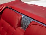 the interior of a red car with a leather seat cover