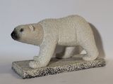 statue d'un ours polaire posée sur une surface blanche, avec un fond blanc