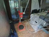 a red and black drill on a table in a room