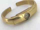 an image of a gold cuff bracelet with a clock on it