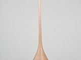 tall wooden vase sitting on a white surface with a gray background