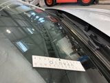 a sign on the windshield of a car that is parked in a parking lot