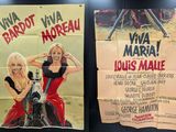 two posters of women in red dresses are hanging on a wall