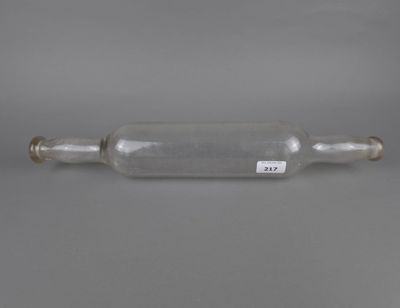 une bouteille en verre vide munie d'un bouchon métallique, posée sur une surface grise
