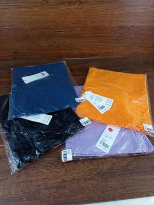 quatre sacs en plastique de différentes couleurs posés sur une table
