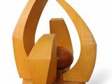 wooden sculpture of a stylized shape on a wooden base