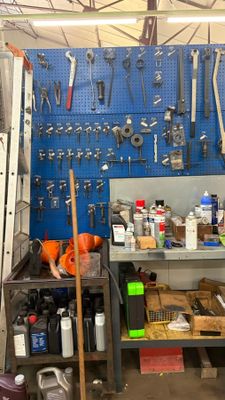 Il y a de nombreux outils accrochés au mur dans ce garage.