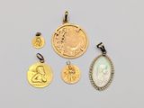 a group of gold and silver coins and pendants on a white surface