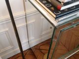 a stack of books sitting on top of a table next to a lamp