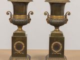 pair of antique brass urns with handles on pedestals