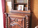 a wooden cabinet with books on top of it in a living room