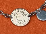 a close up of a necklace with a coin on it