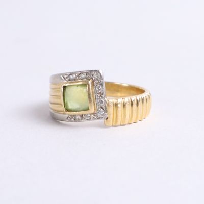 an image of a ring with a green stone surrounded by diamonds