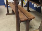 a wooden table and two benches in front of a wall