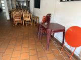 tables and chairs are lined up in a room with orange chairs and pictures on the wall
