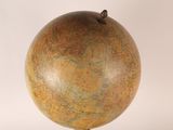 a small globe on a stand on a white surface