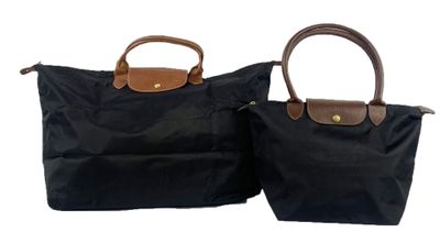 two black bags with brown handles sitting side by side