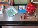 a red vase sitting on a table with other items on it