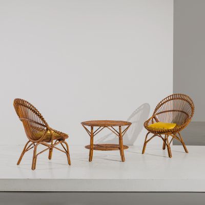 two chairs and a table in a room with a white wall