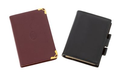 a black and a maroon passport case sitting next to each other
