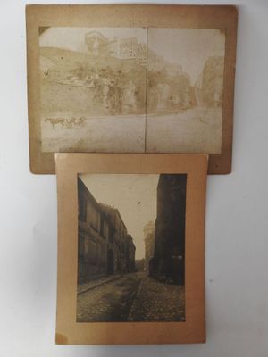 two old photos of a street and a train on a wall