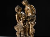 a bronze statue of a man and a woman sitting on a rock
