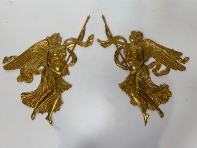 deux figurines d'anges en or posées sur un fond blanc