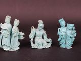 three chinese figurines of women and a man on a black surface