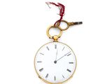 a gold pocket watch with a chain hanging from it ' s side
